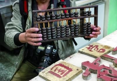 经店家同意，市民范先生收藏了老店的算盘 摄/法制晚报记者 黑克